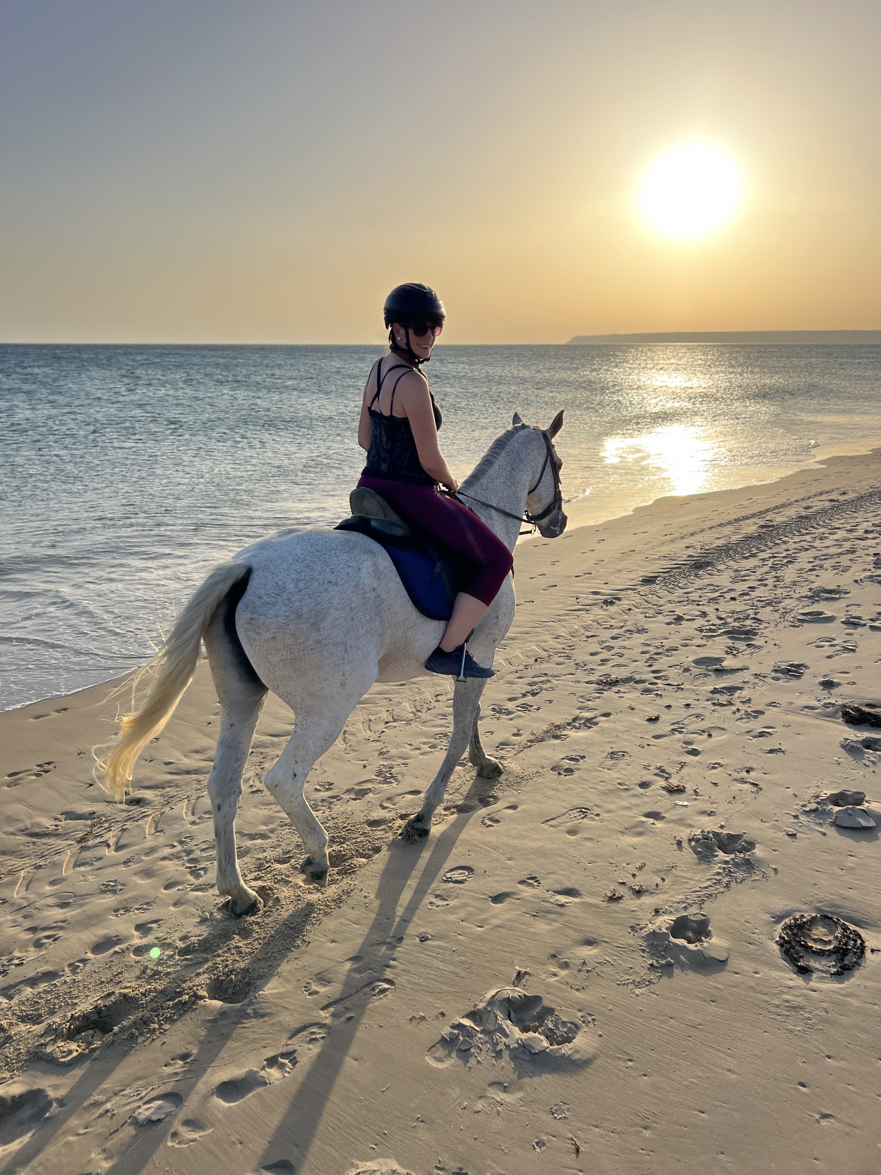 Rider on white horse at golden hour